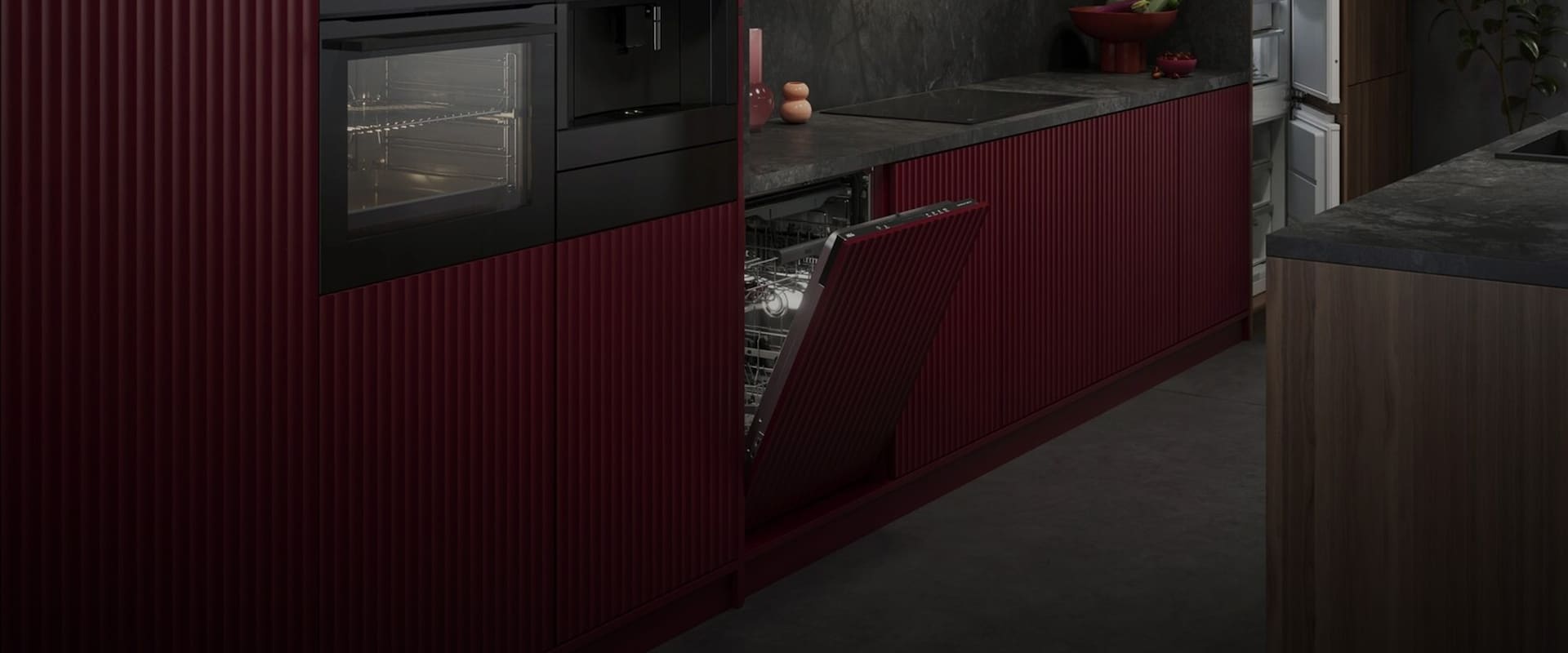 Stilren köksvägg med integrerade AEG-vitvaror inklusive ugn, kaffemaskin och en halvöppen diskmaskin med röda räfflade fronter.